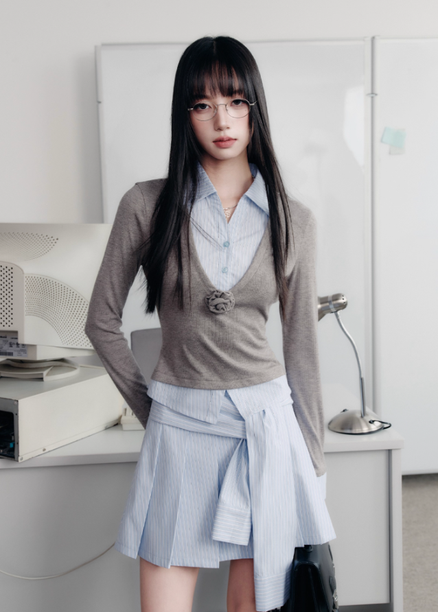 A quiet evolution of the preppy muse — the Blue Prelude Layered Shirt blends striped academia with Fragileheart’s signature delicate poise. The faux two-piece design layers a mist-grey knit over a powder-blue shirt, finished with a minimalist floral accent at the chest. A study in balance, it redefines the modern school-girl aesthetic with luxury subtlety.
