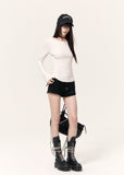 White long-sleeve top with an angel wing back print styled with a black mini skirt and cap