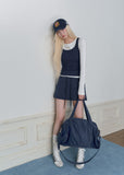 Model wearing a navy and white faux-layered top with a drawstring mini skirt