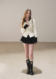 Ivory contrast trim waffle knit cardigan with black pleated mini skirt