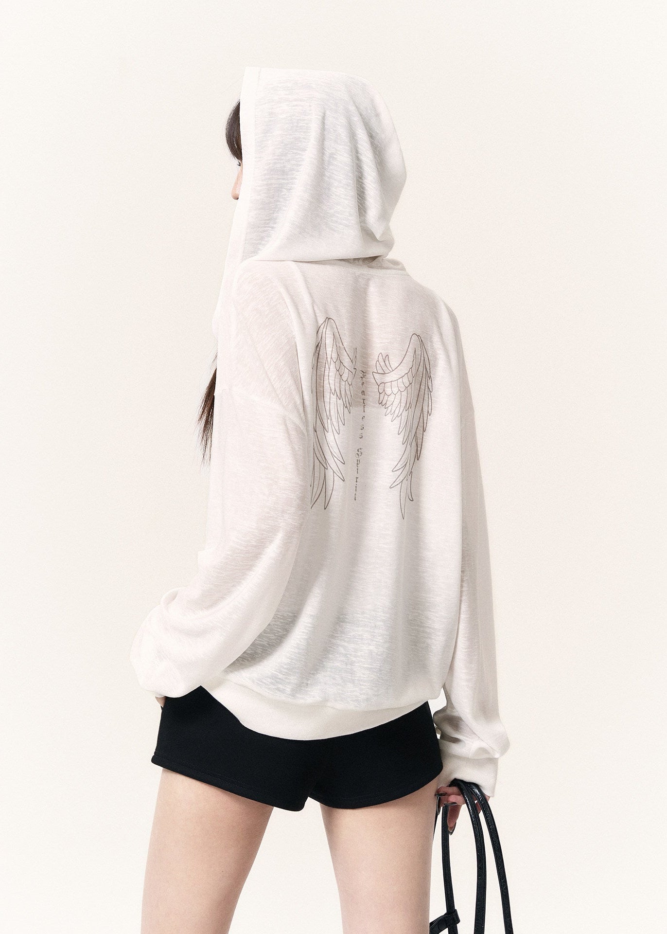 White sheer angel wing zip hoodie styled with fitted black drawstring shorts
