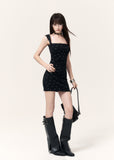Model wearing a black star print mini dress with knee-high boots