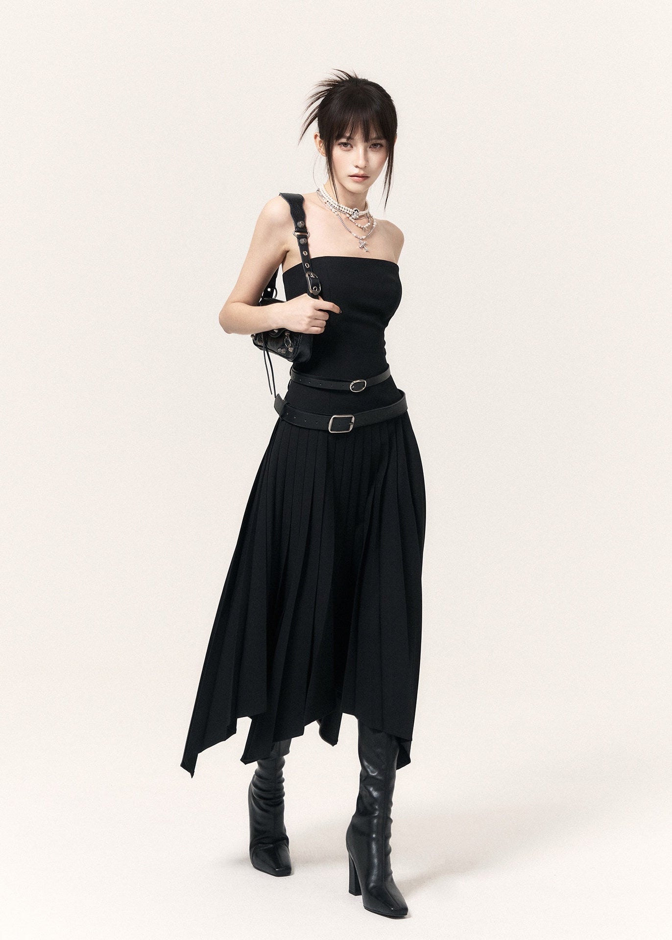 Black strapless midi dress with an asymmetric pleated skirt and wide PU belt