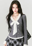 A soft rebellion in knit form — this double-breasted faux two-piece top blends vintage academia with K-fashion sensuality. The ivory bow and pleated trim contrast against charcoal grey, creating a refined silhouette that flatters with quiet confidence. Perfect for 2025 fall looks that balance grace and edge.