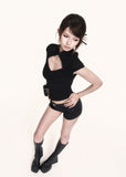 Fitted black short-sleeve top styled with shorts and boots