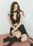 Model wearing black satin-style mini dress with lace panel