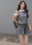 Model wearing a gray sleeveless mini dress with a white contrast collar