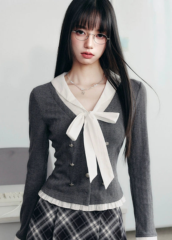 A soft rebellion in knit form — this double-breasted faux two-piece top blends vintage academia with K-fashion sensuality. The ivory bow and pleated trim contrast against charcoal grey, creating a refined silhouette that flatters with quiet confidence. Perfect for 2025 fall looks that balance grace and edge.