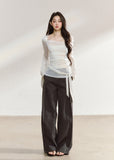 White asymmetric layered long-sleeve top with sheer panels and draped waist ties