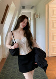 Black low-rise A-line mini skirt styled with an ivory lace camisole