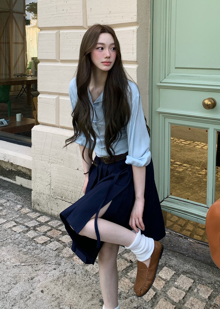 Navy pleated skirt with an asymmetric hem styled with knee-high socks and brown loafers