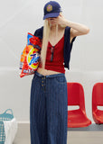 1. Model wearing a fitted red knit camisole with a low neckline and a navy cap