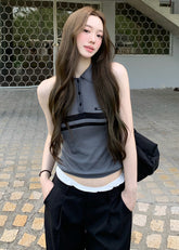 Model wearing a blue-gray sleeveless polo knit top with dark horizontal chest stripes