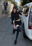 Model wearing a black half-turtleneck knit top and A-line mini skirt set