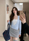 Model wearing a sky-blue asymmetric cross-twist knit top