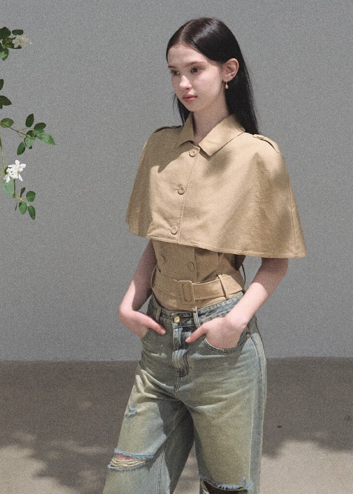 Model wearing a khaki cape-overlay mini dress with a matching belt