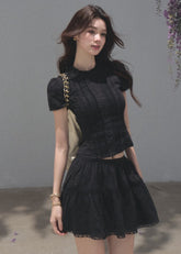 Black fitted top with a matching tiered cake mini skirt