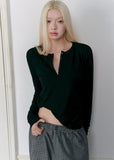 Model wearing a black Tencel-wool Henley long-sleeve top