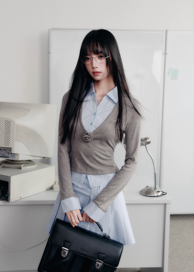 A quiet evolution of the preppy muse — the Blue Prelude Layered Shirt blends striped academia with Fragileheart’s signature delicate poise. The faux two-piece design layers a mist-grey knit over a powder-blue shirt, finished with a minimalist floral accent at the chest. A study in balance, it redefines the modern school-girl aesthetic with luxury subtlety.