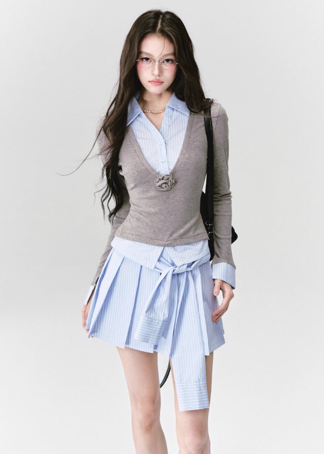 A quiet evolution of the preppy muse — the Blue Prelude Layered Shirt blends striped academia with Fragileheart’s signature delicate poise. The faux two-piece design layers a mist-grey knit over a powder-blue shirt, finished with a minimalist floral accent at the chest. A study in balance, it redefines the modern school-girl aesthetic with luxury subtlety.