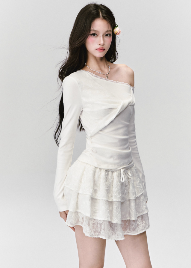 Fragileheart off-shoulder top, white lace blouse, asymmetric draped shirt, luxury Korean fashion, elegant feminine outfit, quiet luxury style, pastel noir aesthetic, winter 2025 collection, modern romantic fashion, ivory one-shoulder knit, soft lace trim top, minimalist luxury wear, Korean chic fashion, delicate off-shoulder blouse
