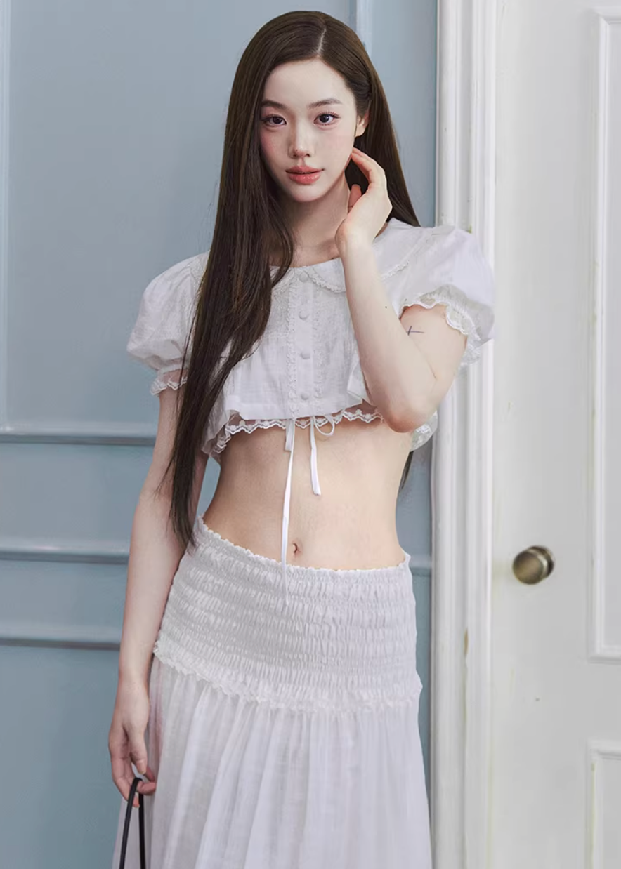 cropped lace blouse women, doll collar top, lace trim blouse, korean fashion top, drawstring blouse women, feminine spring top, lightweight summer blouse, soft girl aesthetic top, white cropped shirt, breathable cotton top, casual romantic blouse, aesthetic fashion top, parisian style clothing, versatile crop top, modern feminine clothing, delicate lace top, chic everyday outfit, airy fabric blouse, youthful style top, spring outfit women