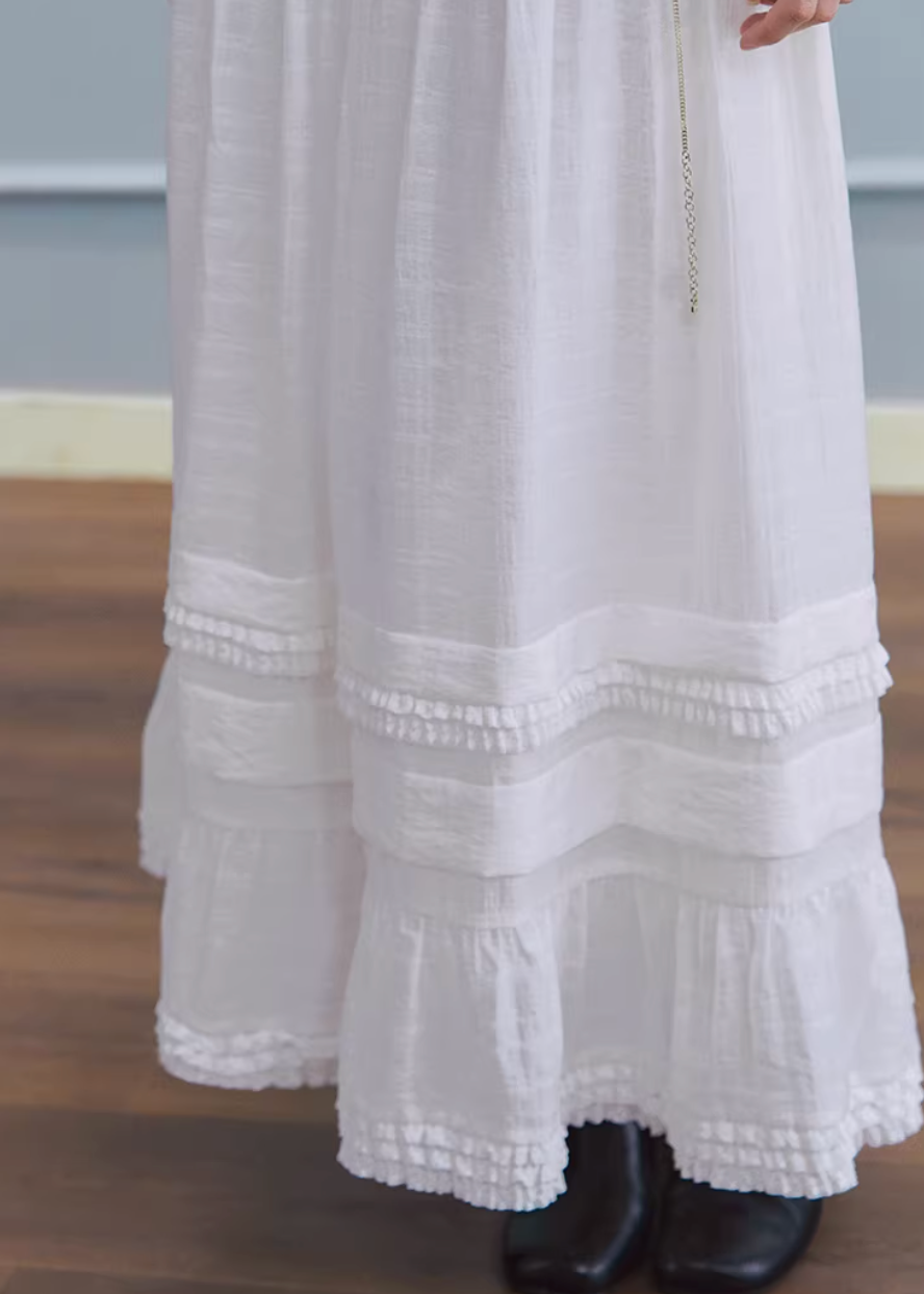 white maxi skirt, pleated long skirt, korean fashion skirt, flowy maxi skirt, elastic waist skirt, feminine long skirt, spring summer skirt, lightweight skirt women, elegant casual outfit, parisian style clothing, soft aesthetic skirt, tiered maxi skirt, breathable fabric skirt, modern feminine clothing, versatile long skirt, chic everyday outfit, refined casual wear, airy fabric skirt, graceful silhouette skirt, minimal elegant skirt