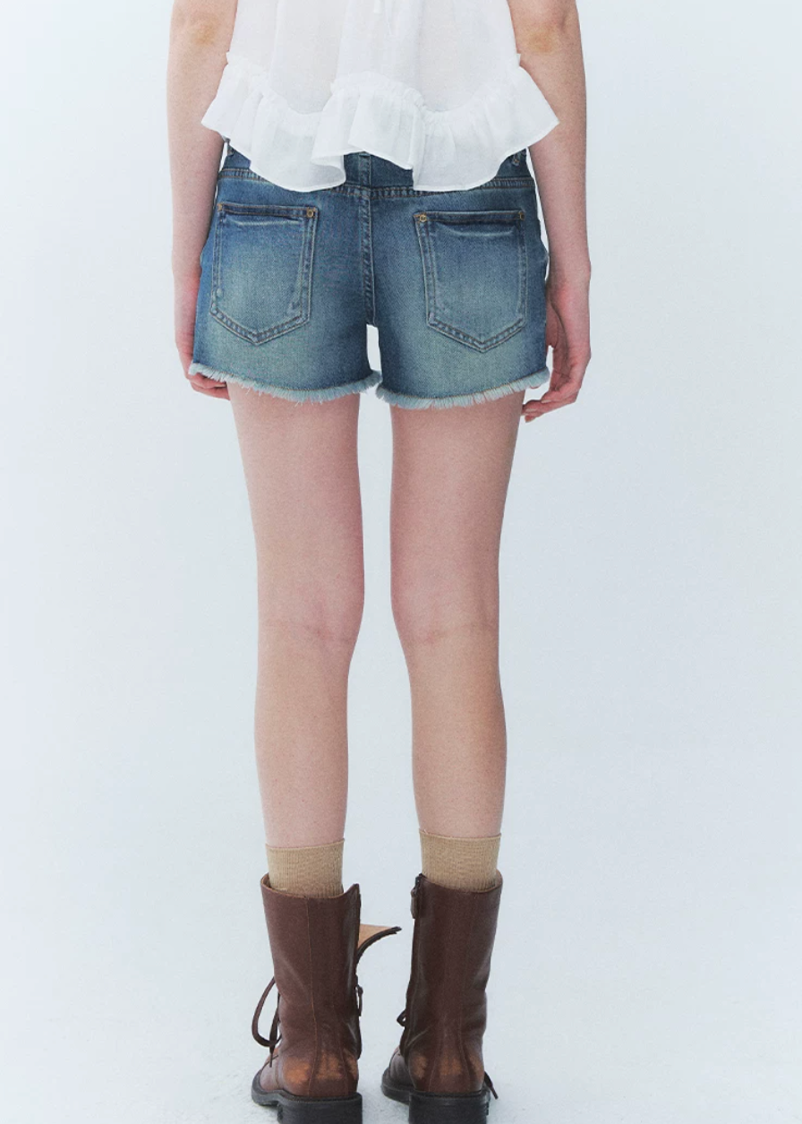 low rise denim shorts, vintage denim shorts, fringe denim shorts, distressed denim shorts, cat whisker shorts, American vintage shorts, women’s hot shorts, casual denim shorts, summer denim shorts, frayed hem shorts, Korean feminine styling, resort denim shorts, cotton blend denim shorts, washed denim shorts, vacation shorts outfit