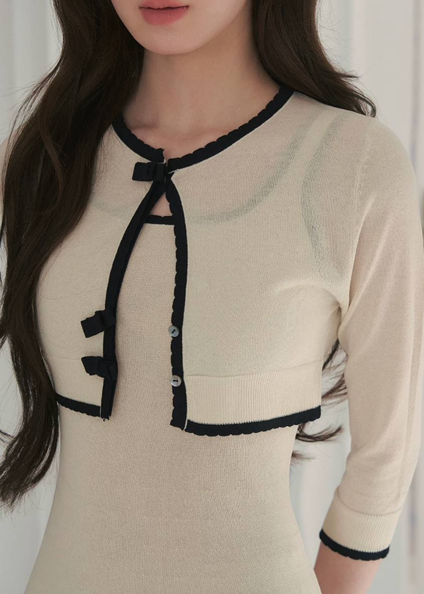 short sleeve knit cardigan, cropped knit cardigan, bow closure cardigan, asymmetric cardigan, cream knit cardigan, French style cardigan, Korean feminine cardigan, contrast trim cardigan, soft knit top, summer layering cardigan, romantic knit cardigan, feminine Korean fashion, vintage inspired cardigan, cream bow cardigan, lightweight knit cardigan