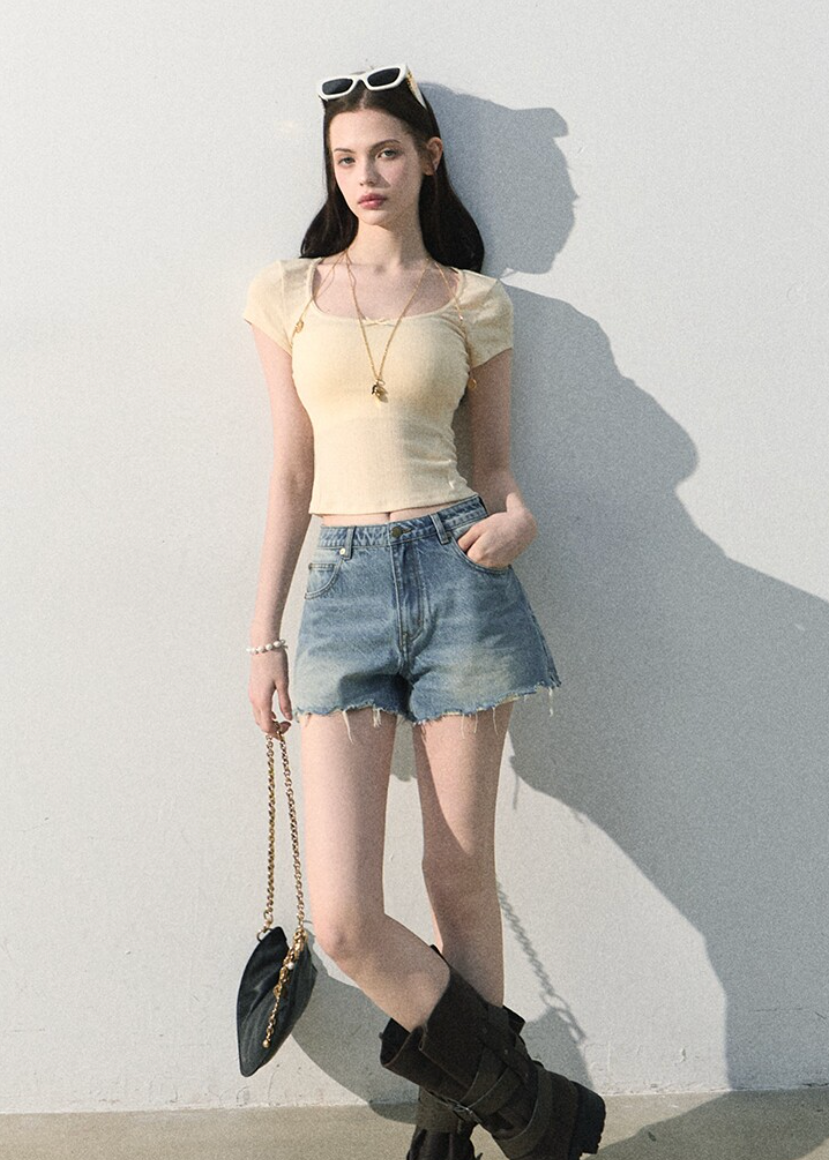 Front view of fitted mint top styled with light-wash denim