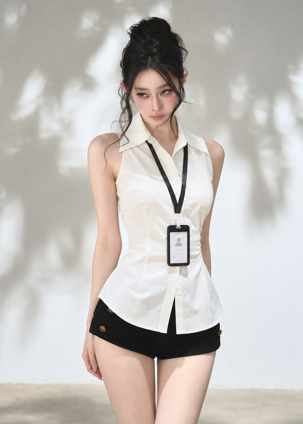 Black knit overlay with waist buckle paired with white button-front shirt