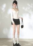Women's fitted ivory knit top with delicate neckline straps and buttons