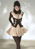 Brown cold-shoulder cardigan layered over a beige flared knit dress