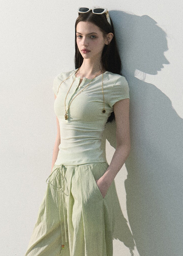 Mint green stretch-knit tee styled with relaxed trousers