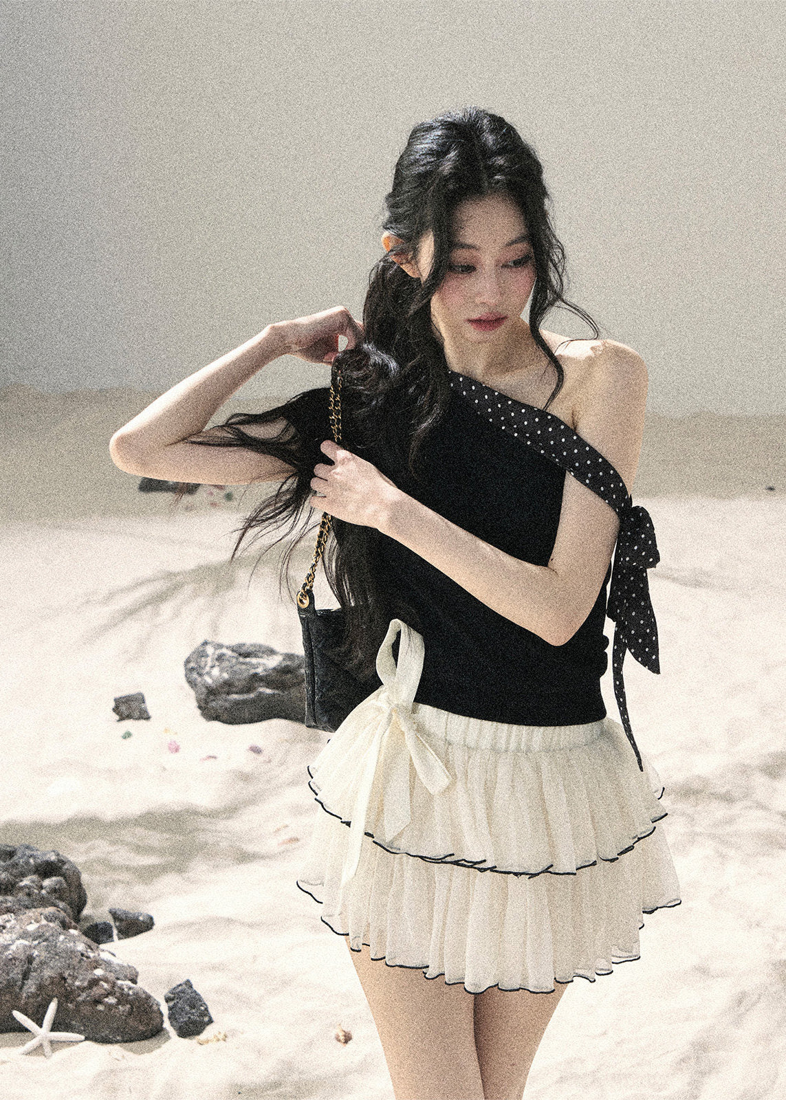 Black one-shoulder knit top with polka dot ribbon bow detail