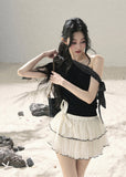 Black one-shoulder knit top with polka dot ribbon bow detail