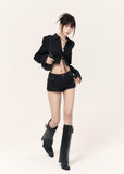 Black lace-up cropped shirt with structured puff sleeves styled with denim shorts