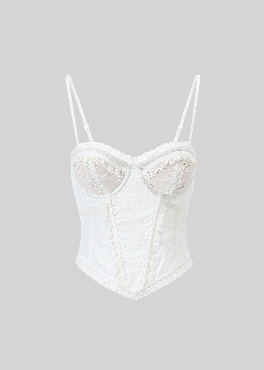 Model wearing an ivory embroidered corset camisole under a dark blazer