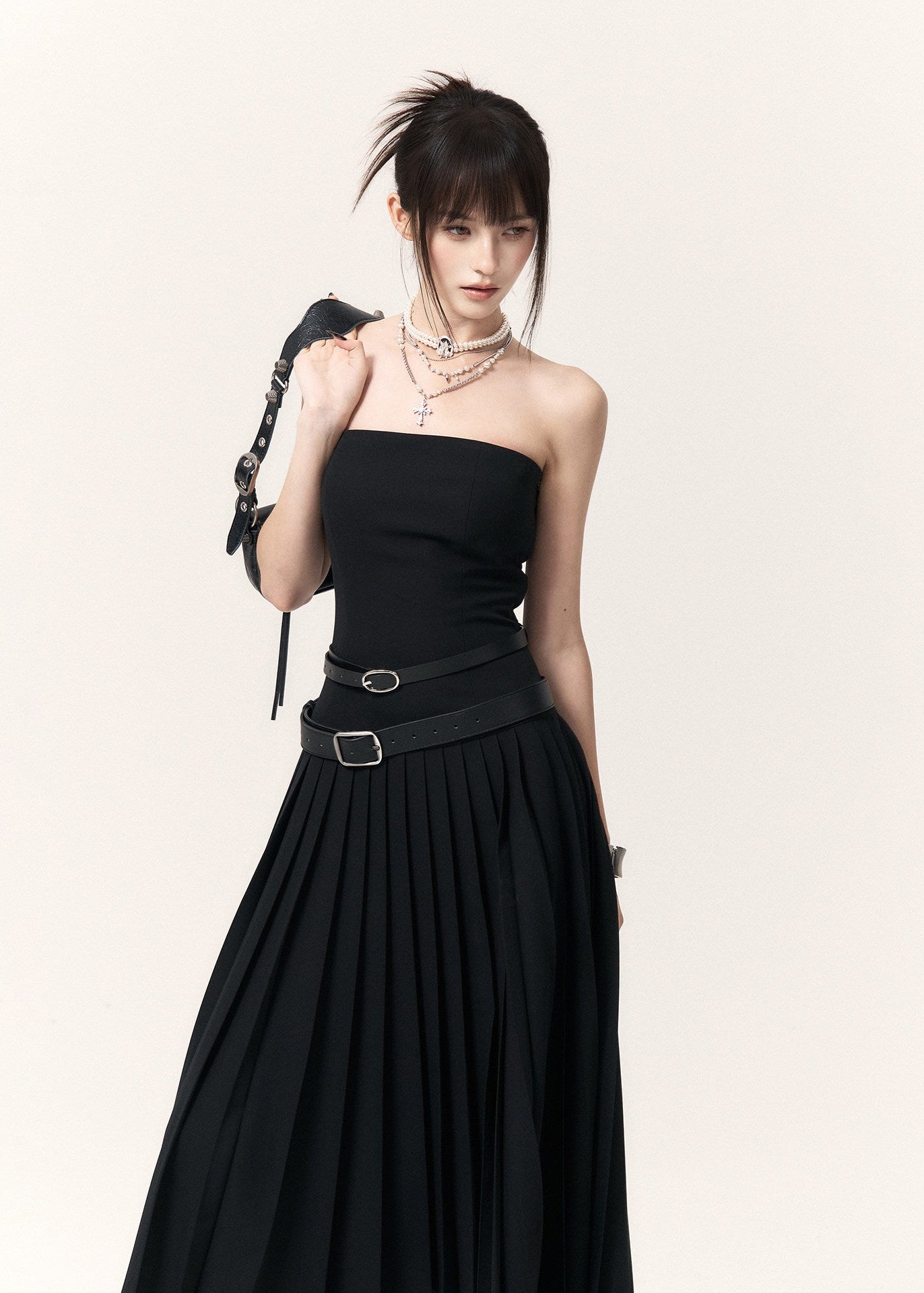 Black strapless midi dress with an asymmetric pleated skirt and wide PU belt