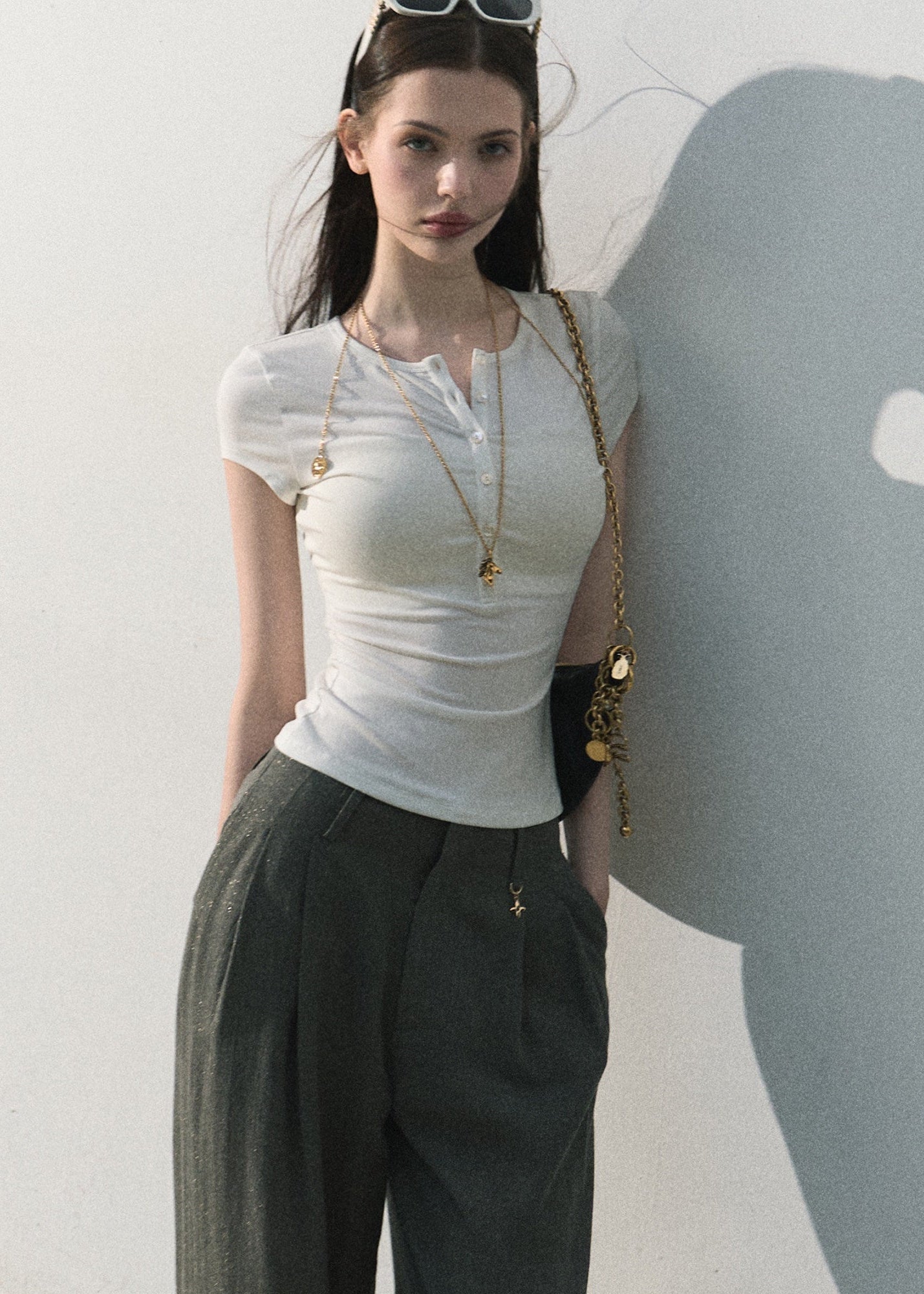 White fitted button-neck tee styled with wide-leg trousers