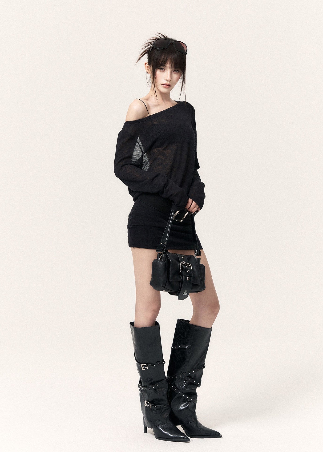 Front view of a fitted black mini dress with a sheer neckline and wide waist belt