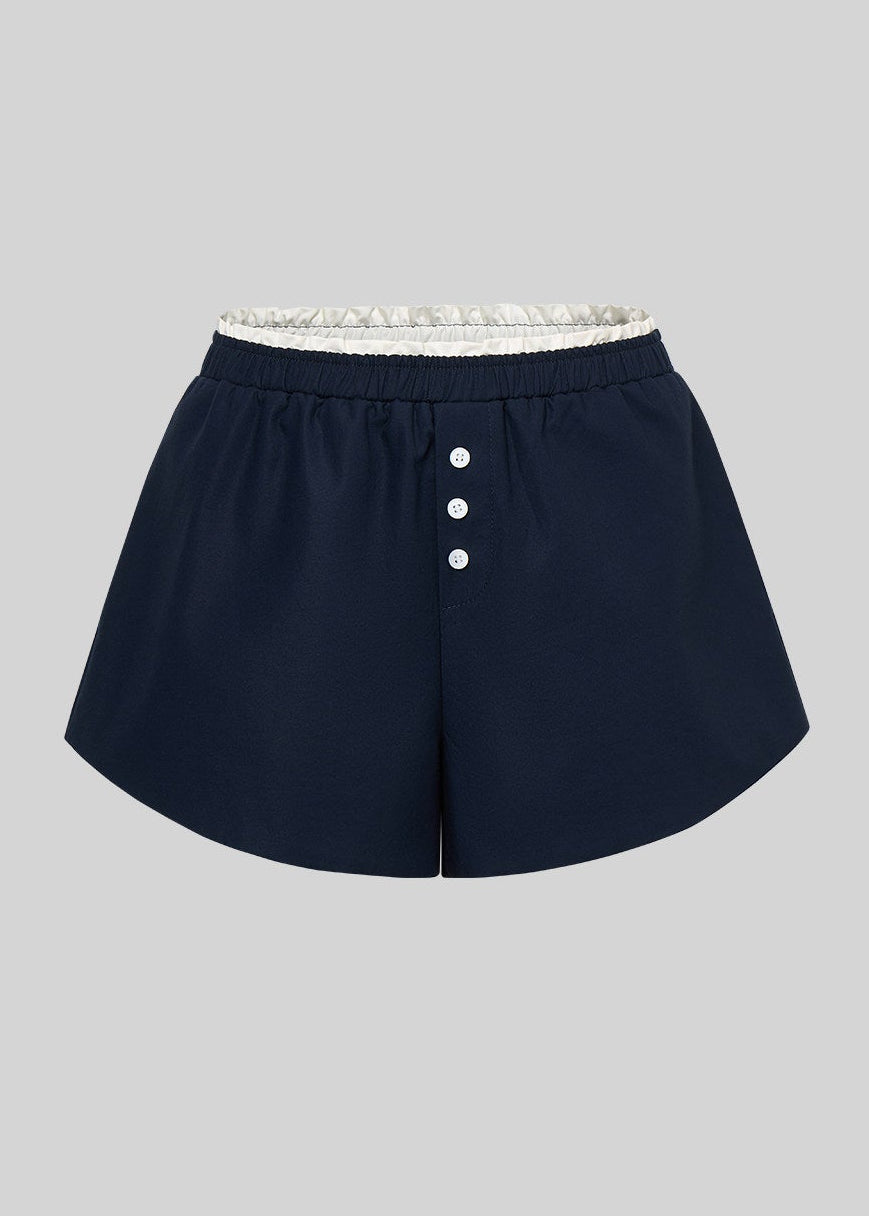 Navy button-detail shorts displayed against a light gray background