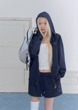 Model wearing a navy embroidered zip-up hoodie and drawstring sweatpants set