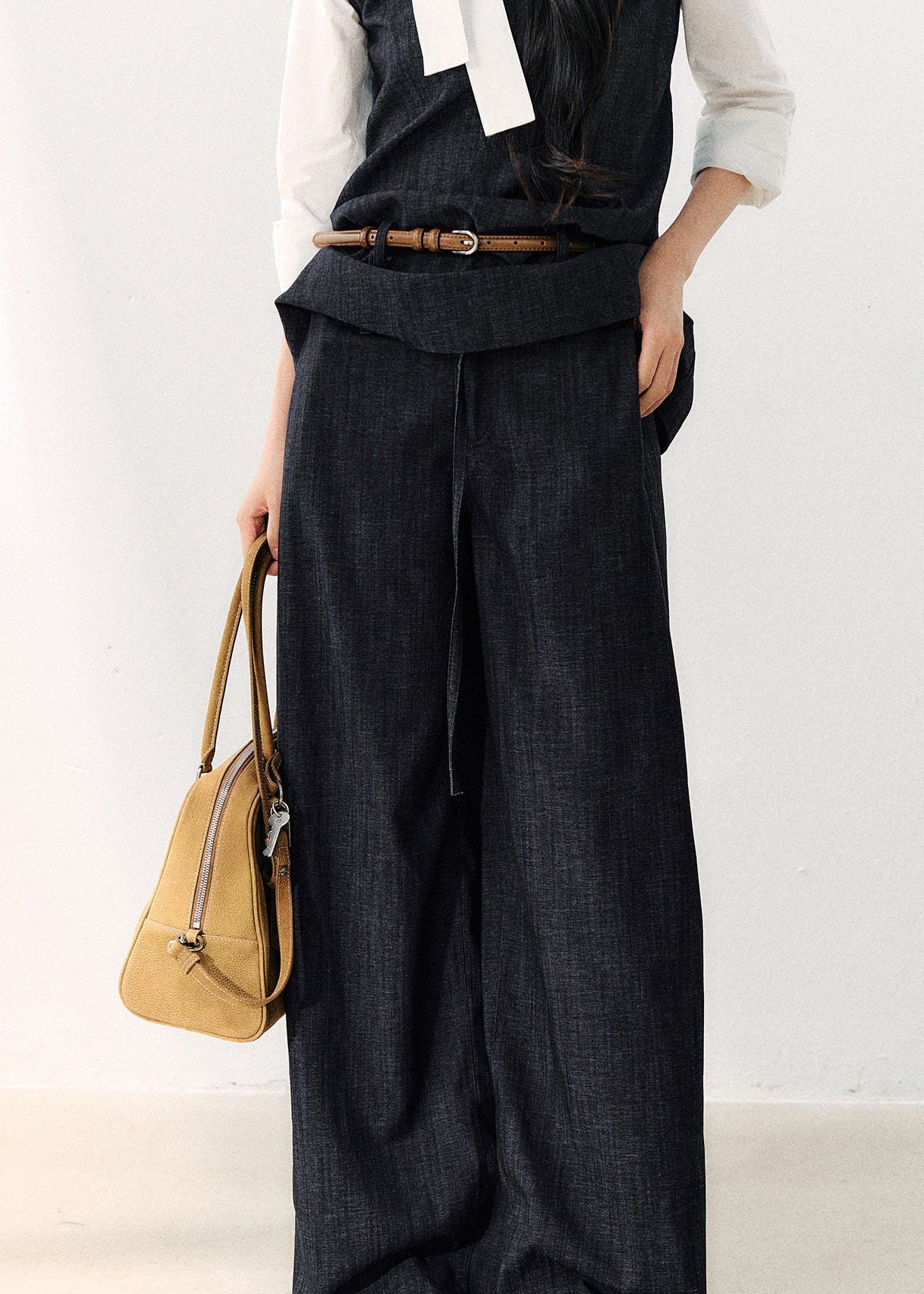 Dark indigo pleated wide-leg trousers with a foldover waist