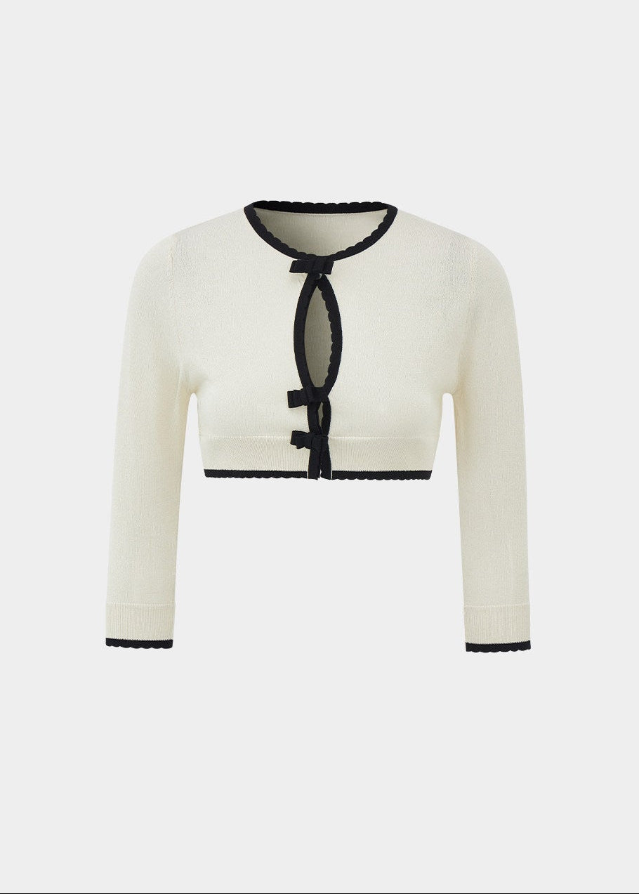 short sleeve knit cardigan, cropped knit cardigan, bow closure cardigan, asymmetric cardigan, cream knit cardigan, French style cardigan, Korean feminine cardigan, contrast trim cardigan, soft knit top, summer layering cardigan, romantic knit cardigan, feminine Korean fashion, vintage inspired cardigan, cream bow cardigan, lightweight knit cardigan