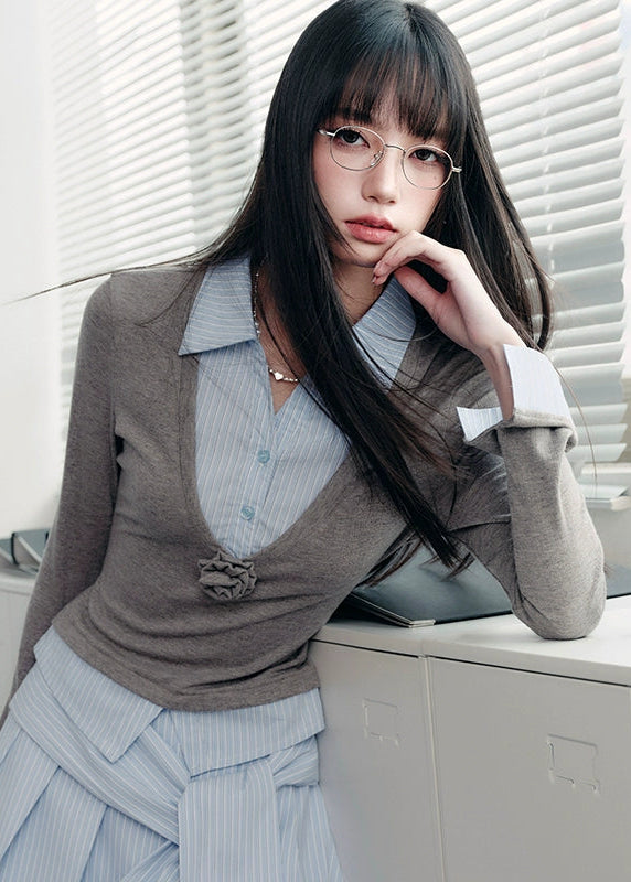 A quiet evolution of the preppy muse — the Blue Prelude Layered Shirt blends striped academia with Fragileheart’s signature delicate poise. The faux two-piece design layers a mist-grey knit over a powder-blue shirt, finished with a minimalist floral accent at the chest. A study in balance, it redefines the modern school-girl aesthetic with luxury subtlety.