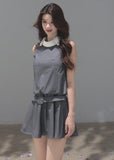 Model wearing a gray sleeveless mini dress with a white contrast collar