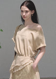 Model wearing a beige asymmetric mini dress with a lace apron overlay