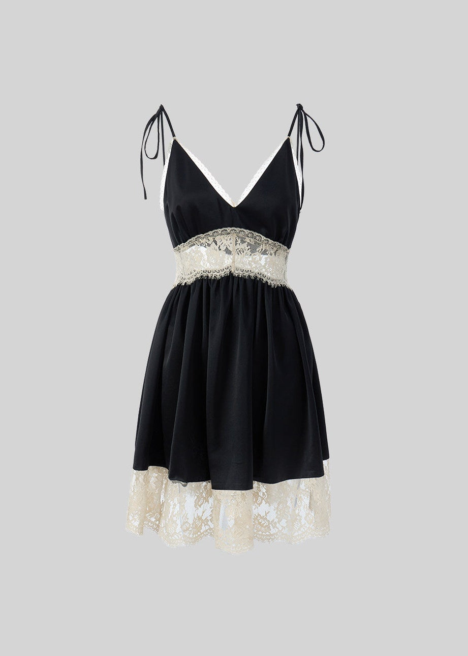Model wearing black satin-style mini dress with lace panel