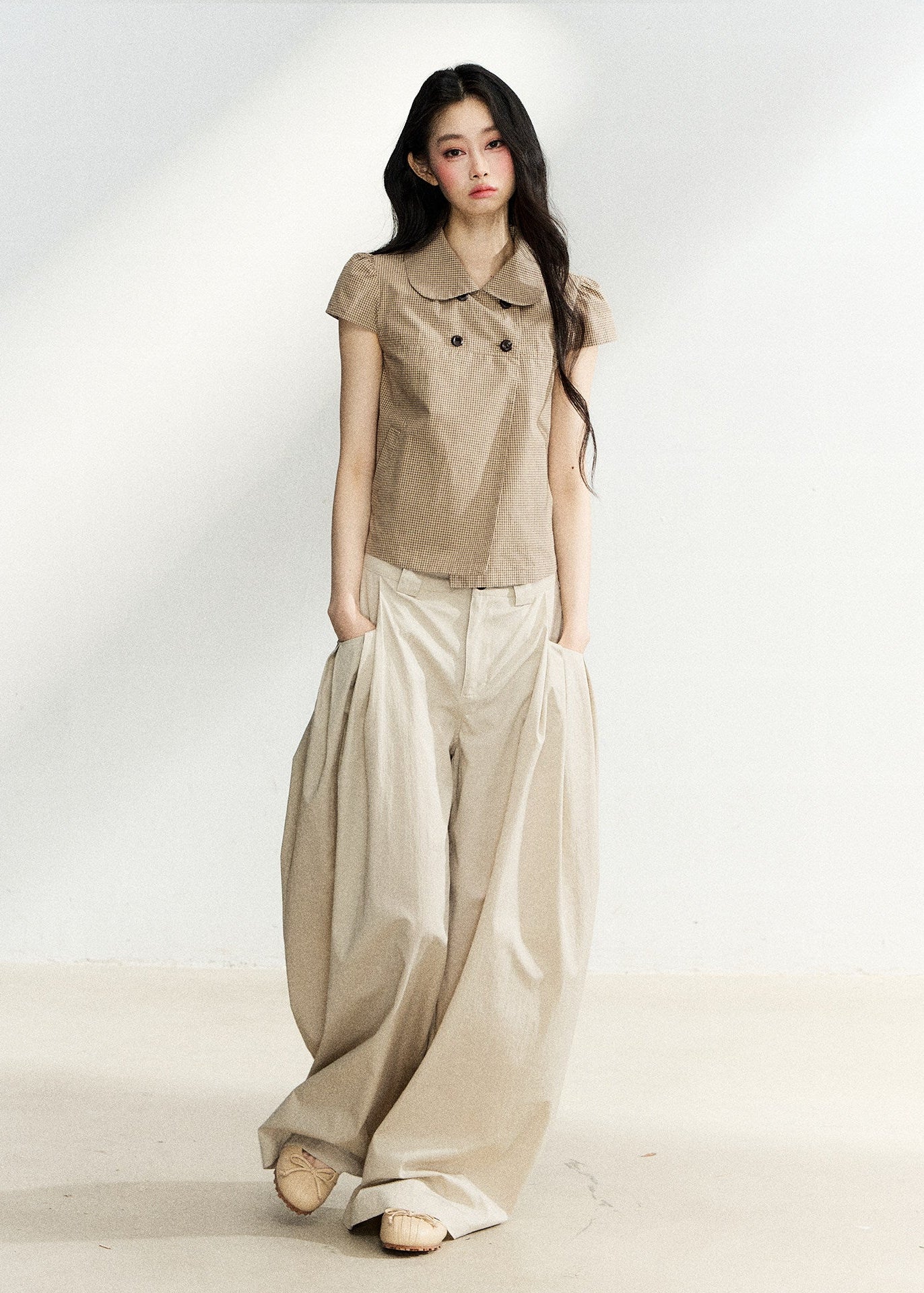 Beige high-waisted wide-leg trousers with side pleats